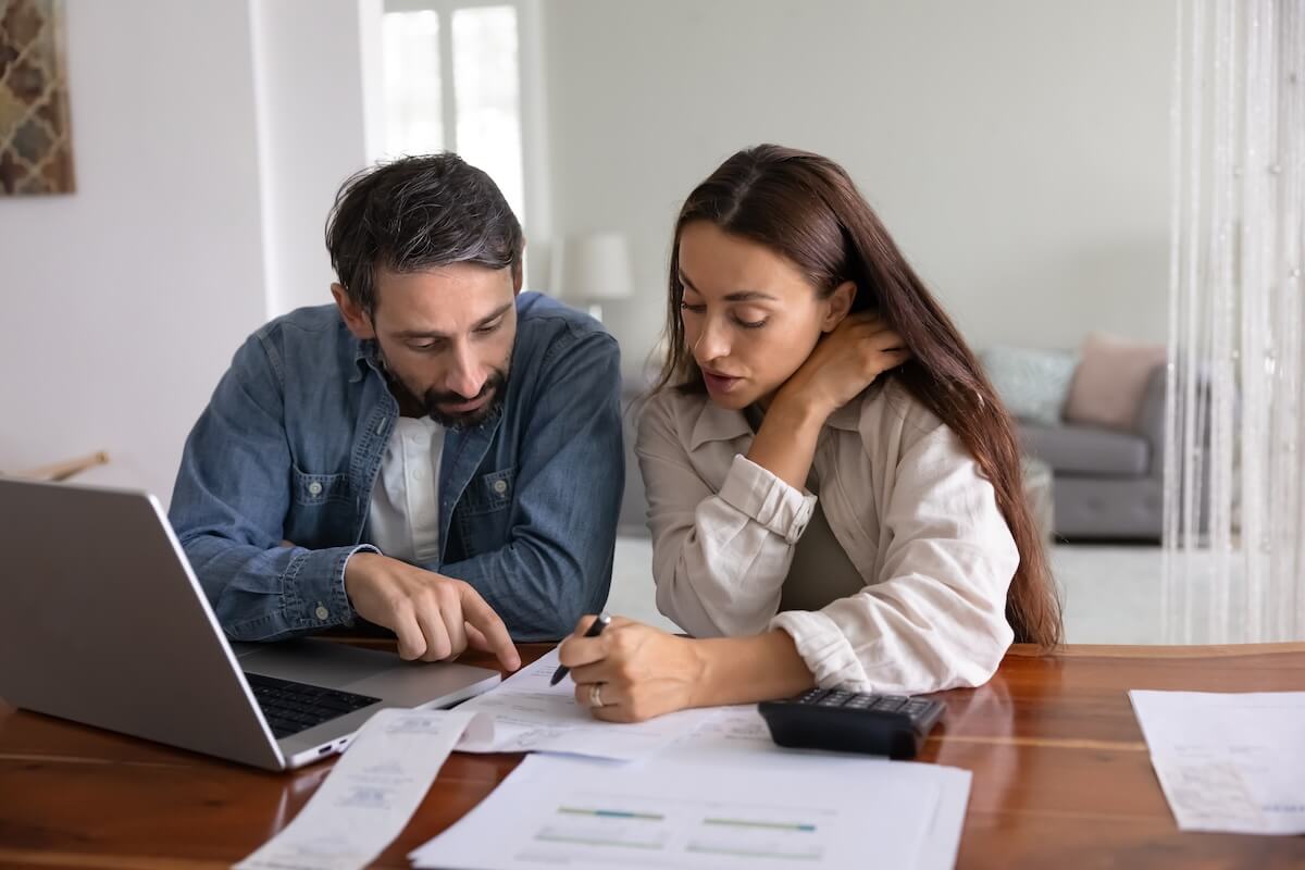 A couple sits at a table reading a document together