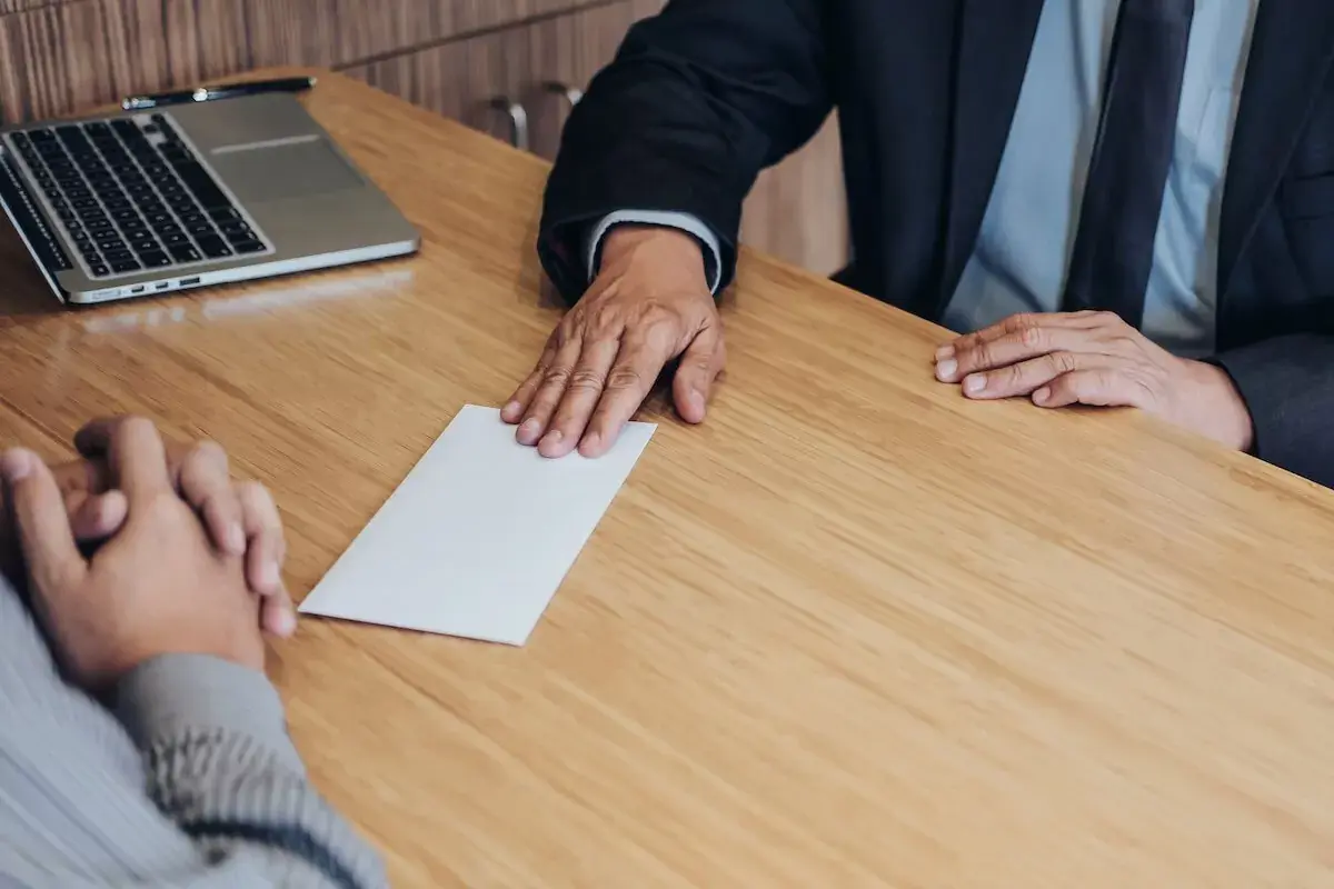 employee-handing-an-envelope-to-his-boss.jpeg-1
