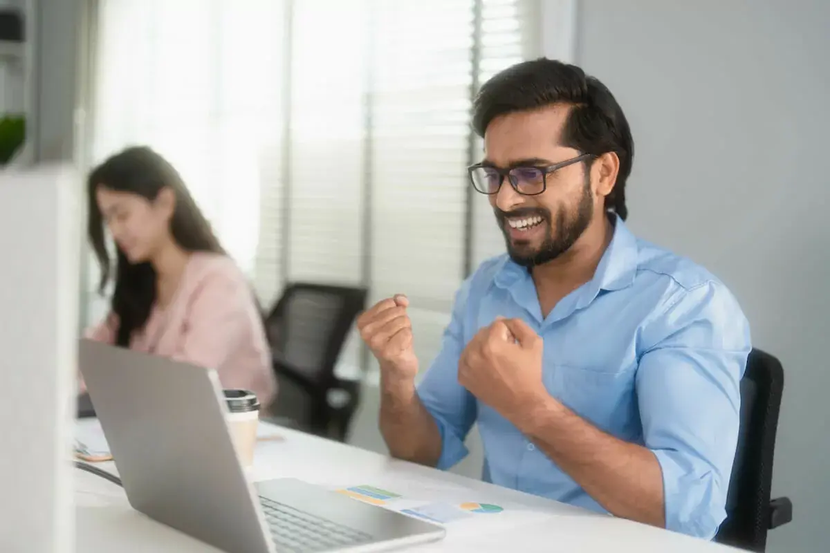 employee-happily-looking-at-his-laptop.jpeg