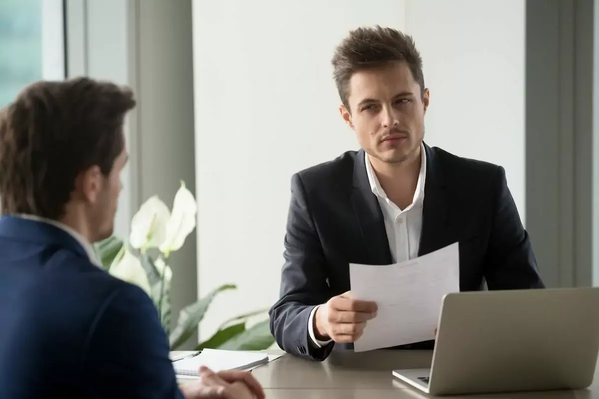 employee-looking-at-a-client-while-holding-a-piece-of-paper.jpeg