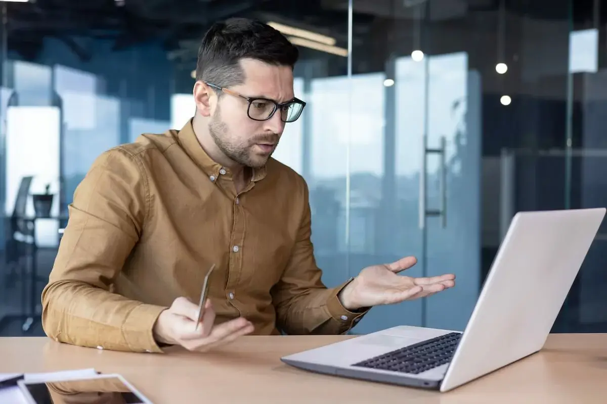 man-looking-at-his-laptop-while-holding-a-credit-card.jpeg