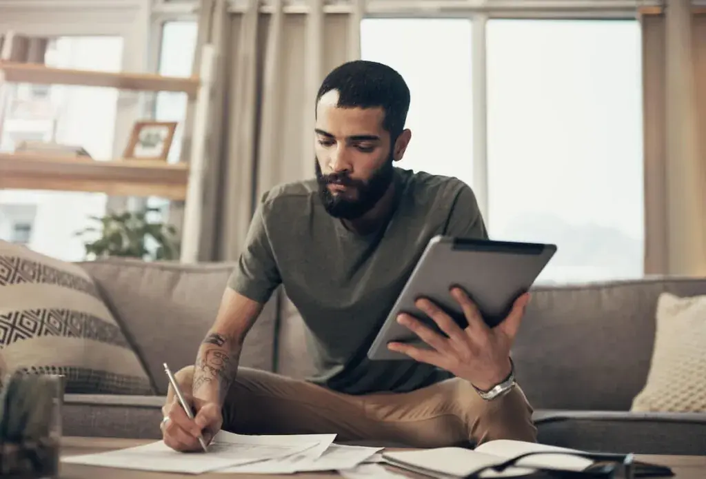 man-writing-on-a-piece-of-paper-while-holding-a-tablet-1024x695.jpeg