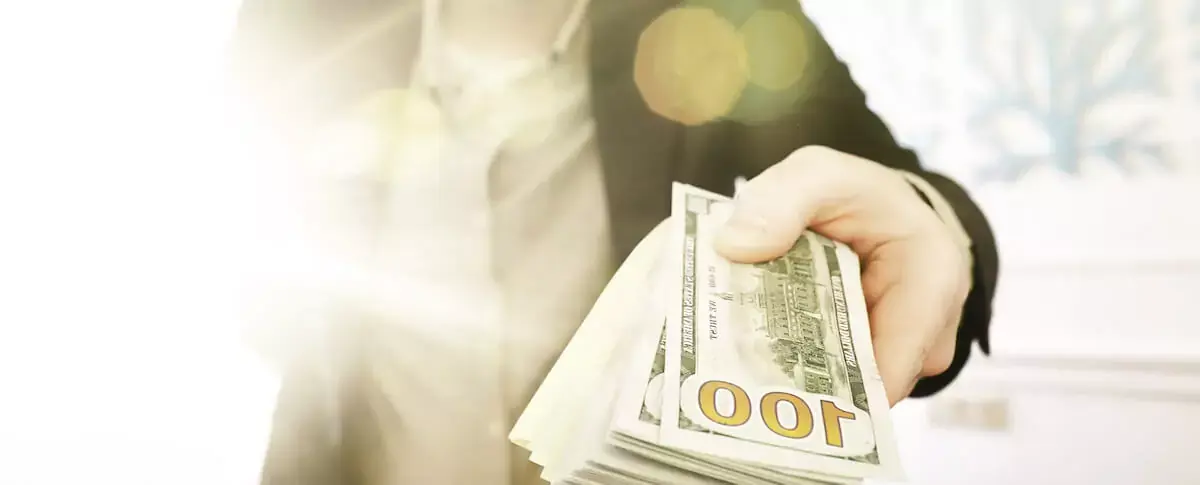 person-holding-a-stack-of-bills.jpeg