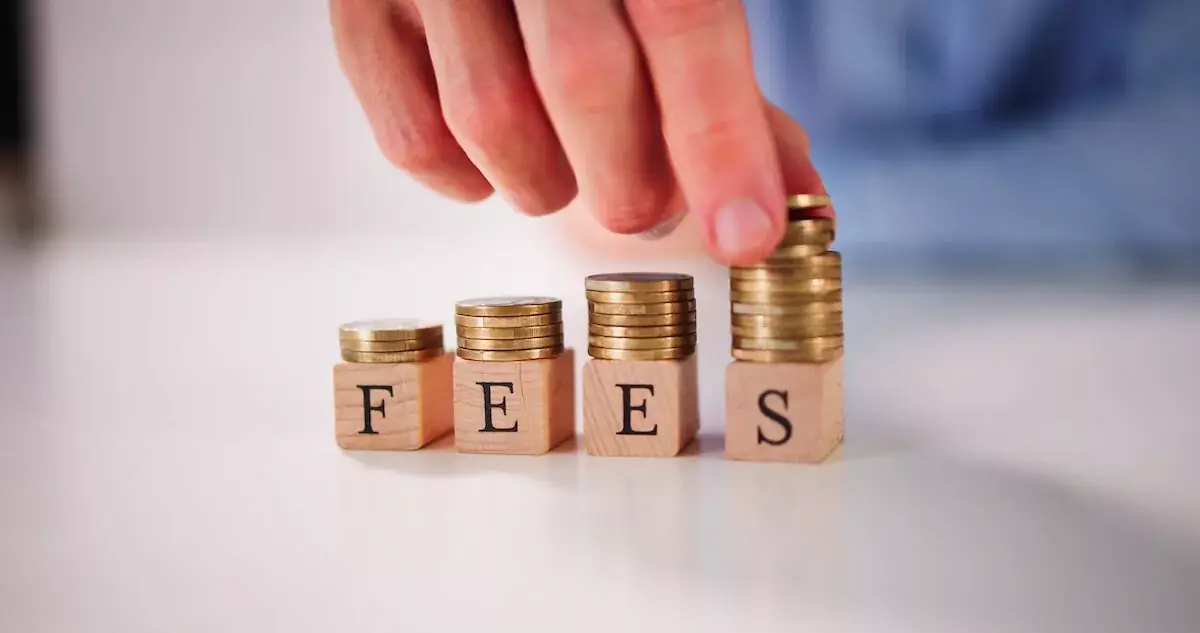 person-stacking-coins-on-wooden-blocks-with-FEES-written-on-it.jpeg
