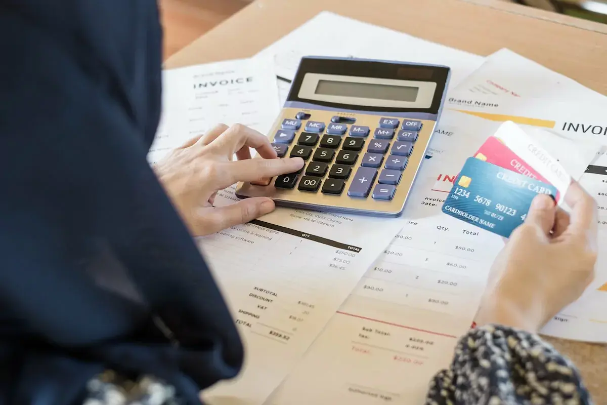 person-using-a-calculator-while-holding-3-credit-cards.jpeg