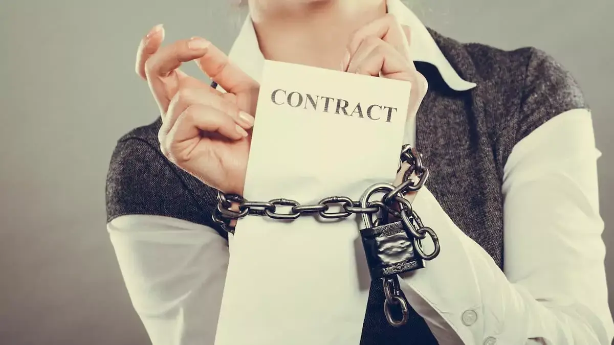 person-with-chained-hands-and-contract.jpeg