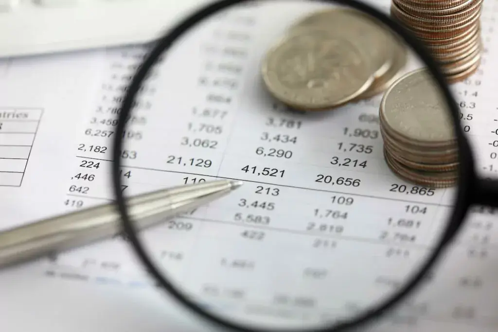 using-a-magnifying-glass-to-view-coins-a-pen-and-a-document-1024x683.jpeg
