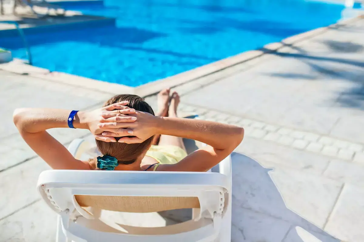 woman-sitting-on-a-bench-beside-a-pool.jpeg