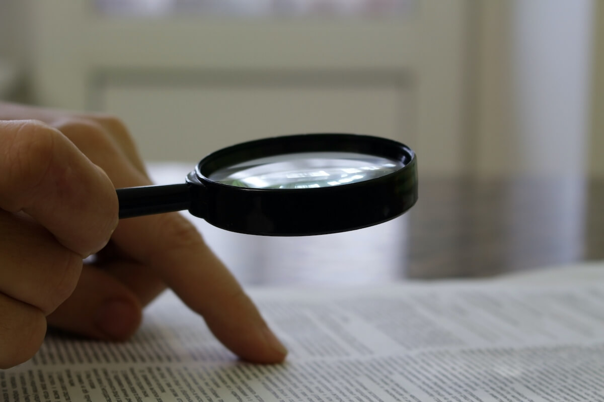 timeshare lawyers: person holding a magnifying glass over a contract