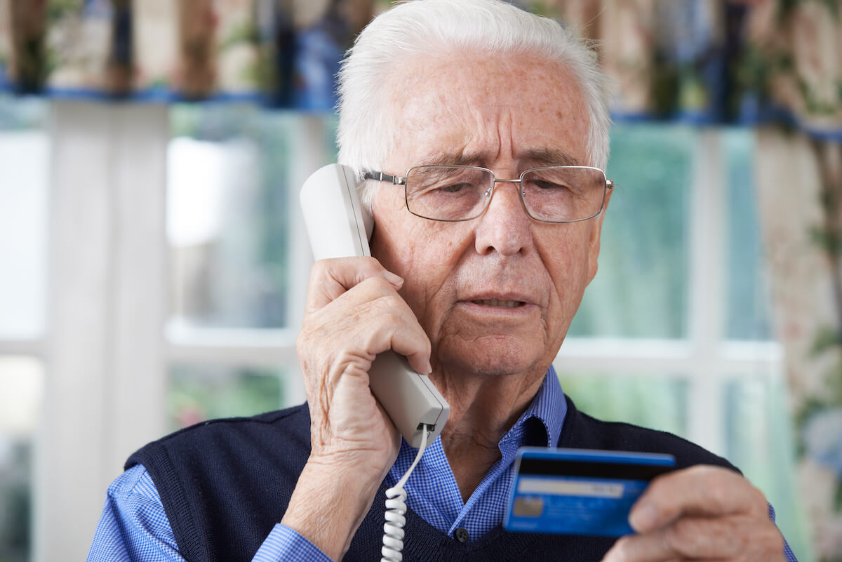 Elderly man on the phone giving his credit card details