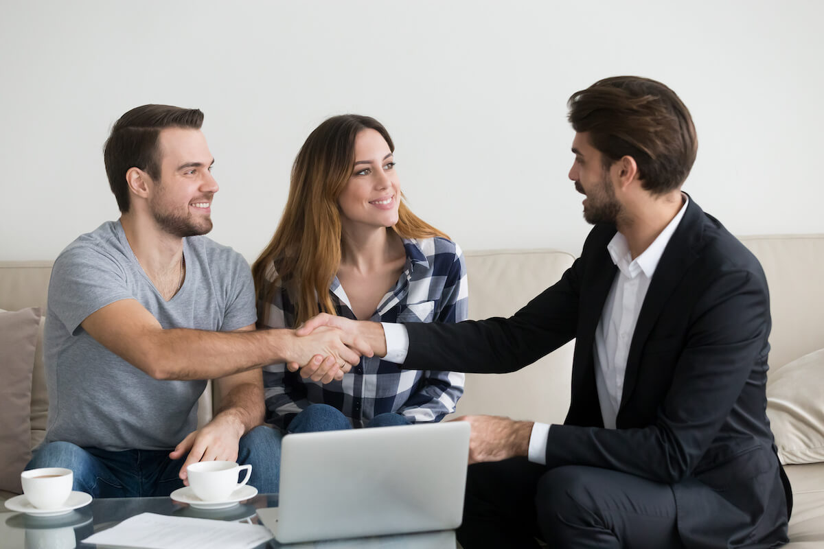 Couple shaking hands with an agent