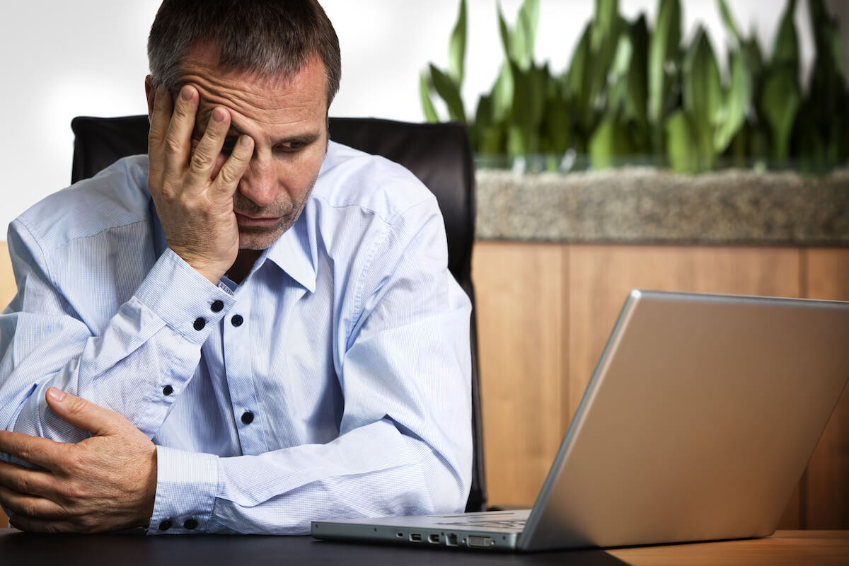 Interval International: frustrated man looking at his laptop