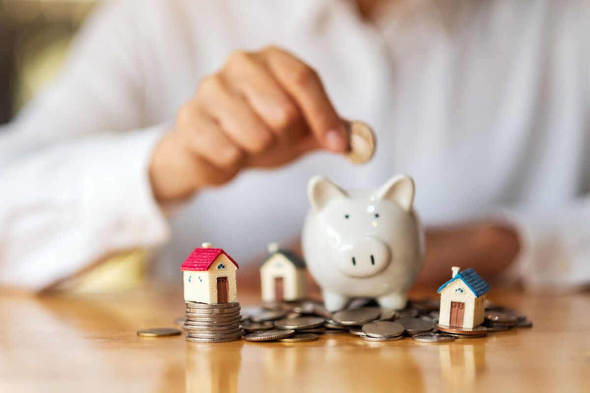 Are timeshares a good investment: person putting coins into a piggy bank