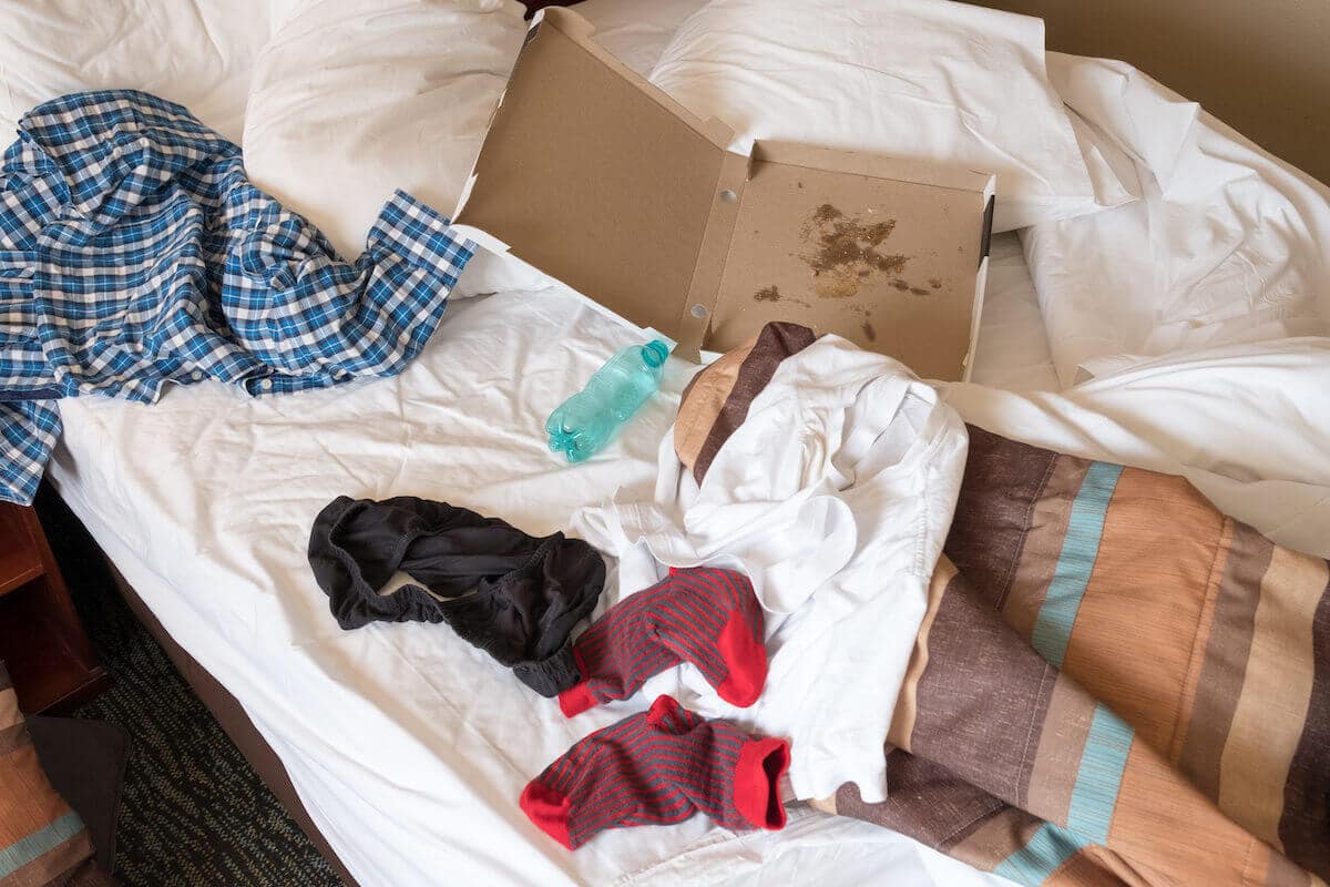 Westgate timeshare reviews: messy bed with clothes and a pizza box on it
