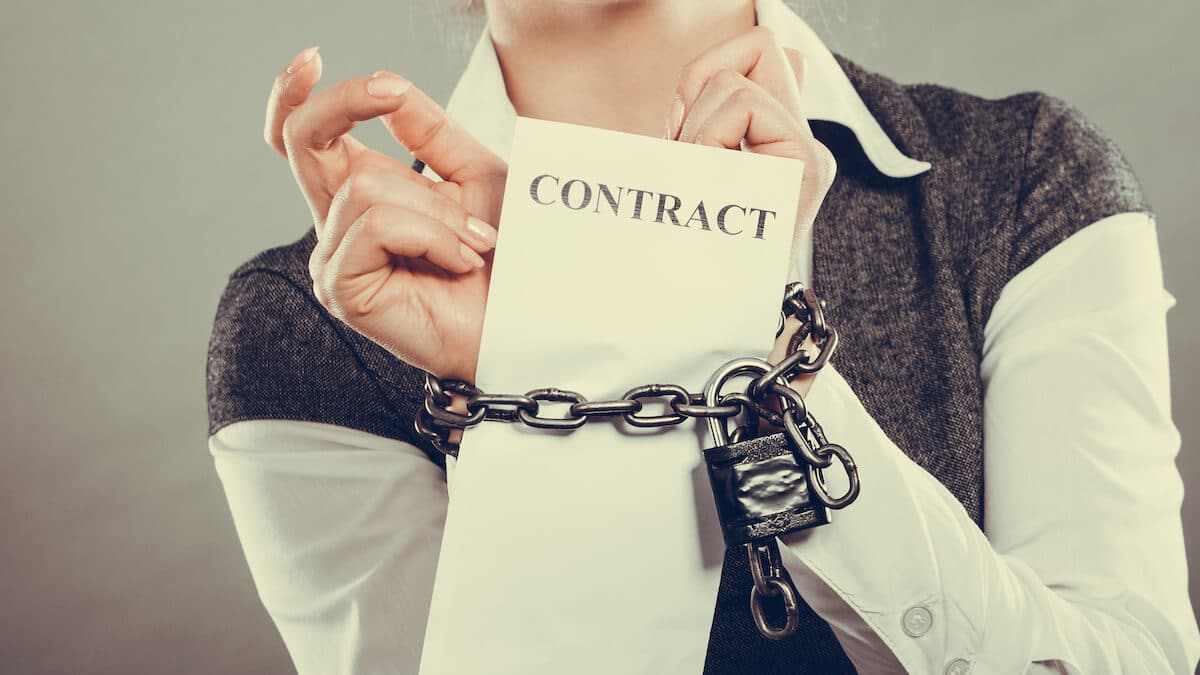 Person with chained hands and a contract