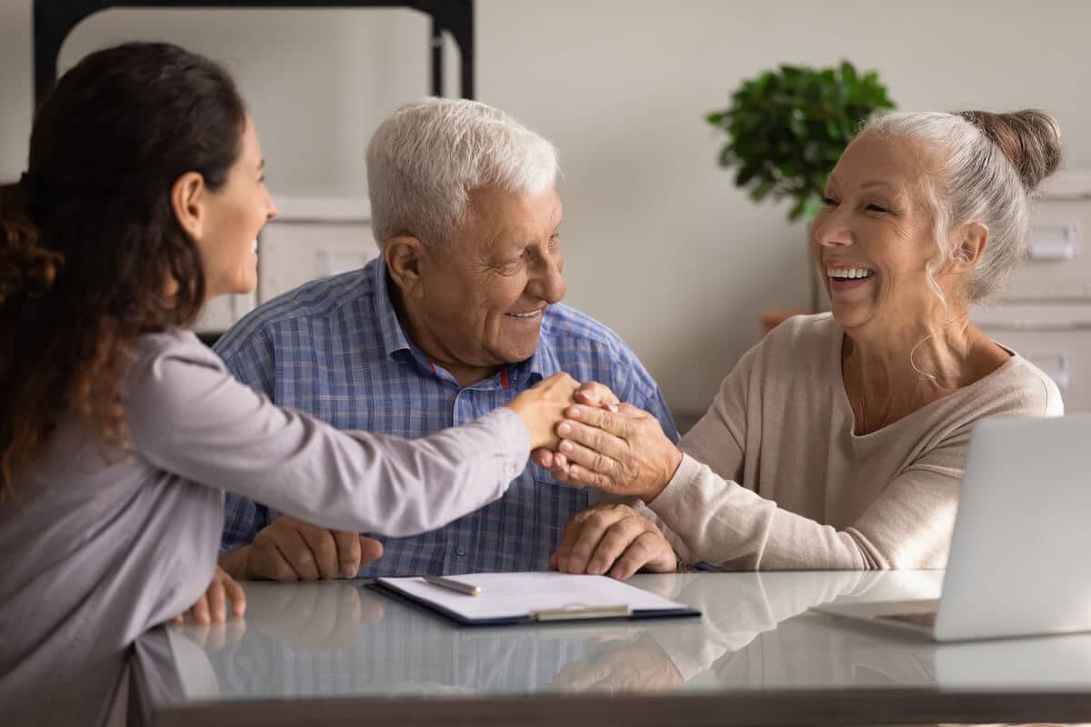 Capital Vacations: elderly couple happily shaking hands with an agent