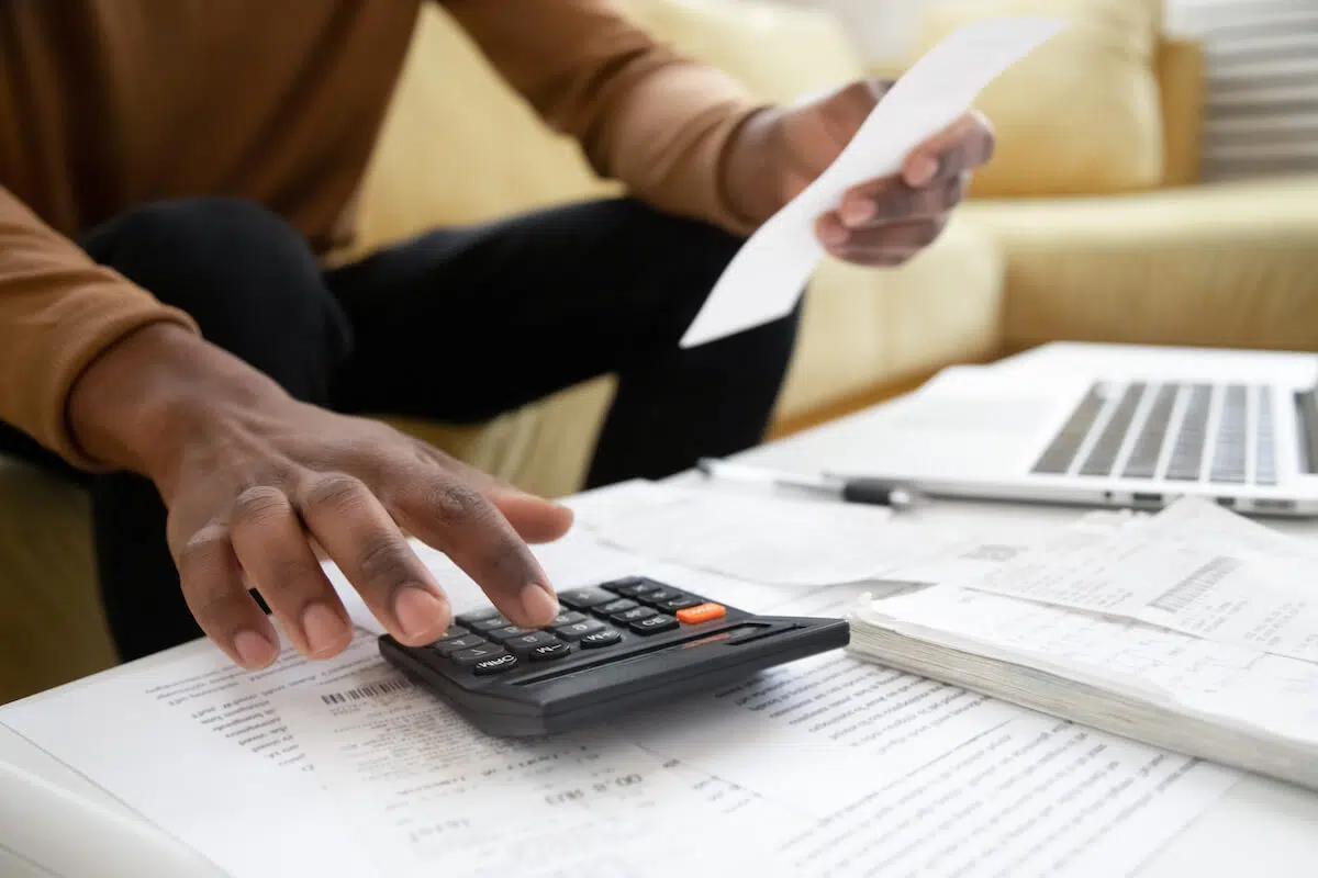 Refinance timeshares: person using a calculator and holding a receipt