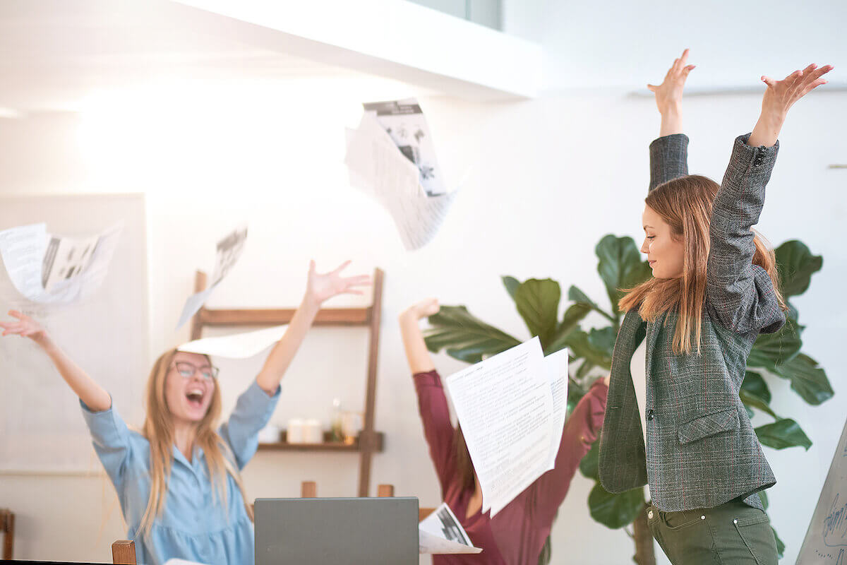 Timeshare alternatives: happy colleagues throwing papers in celebration