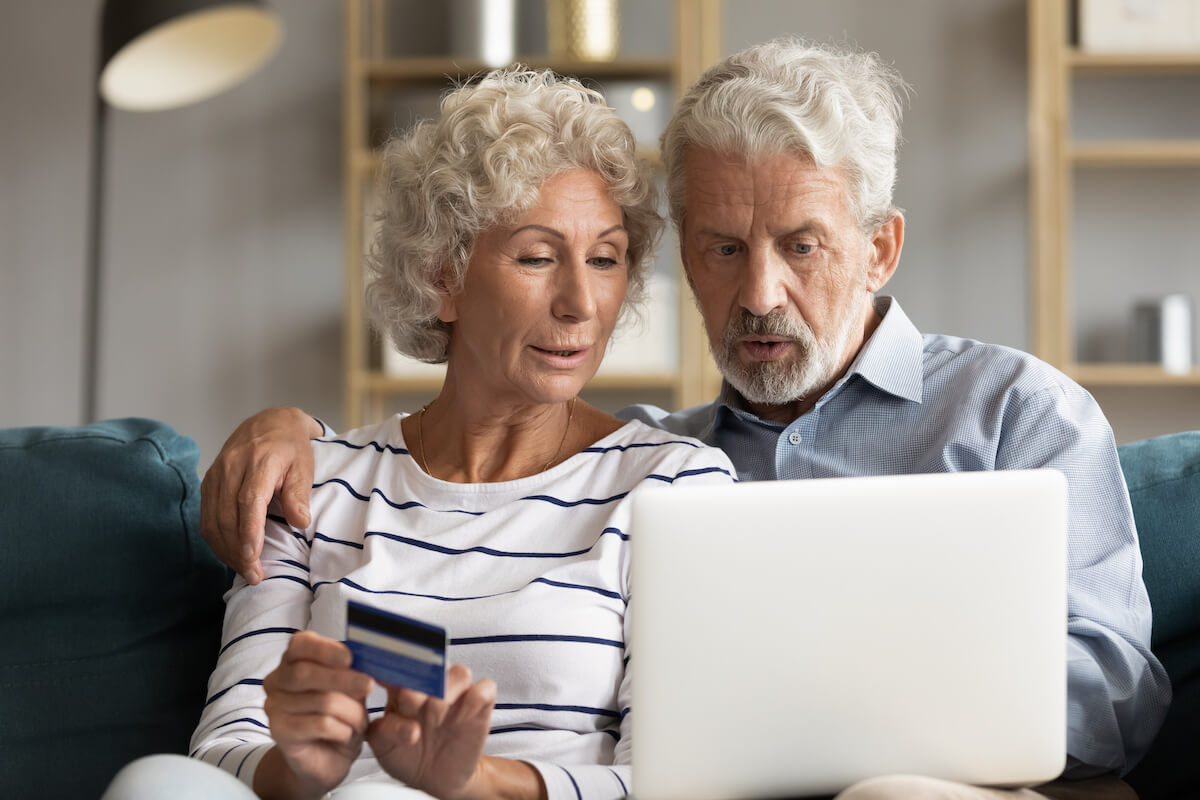 Couple using a laptop and holding a credit card