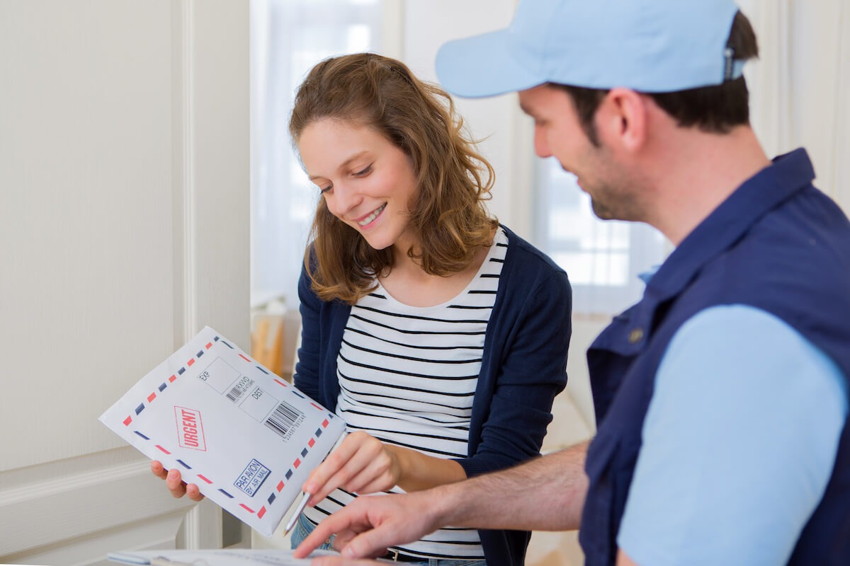 Delivery man handing an envelope to a woman