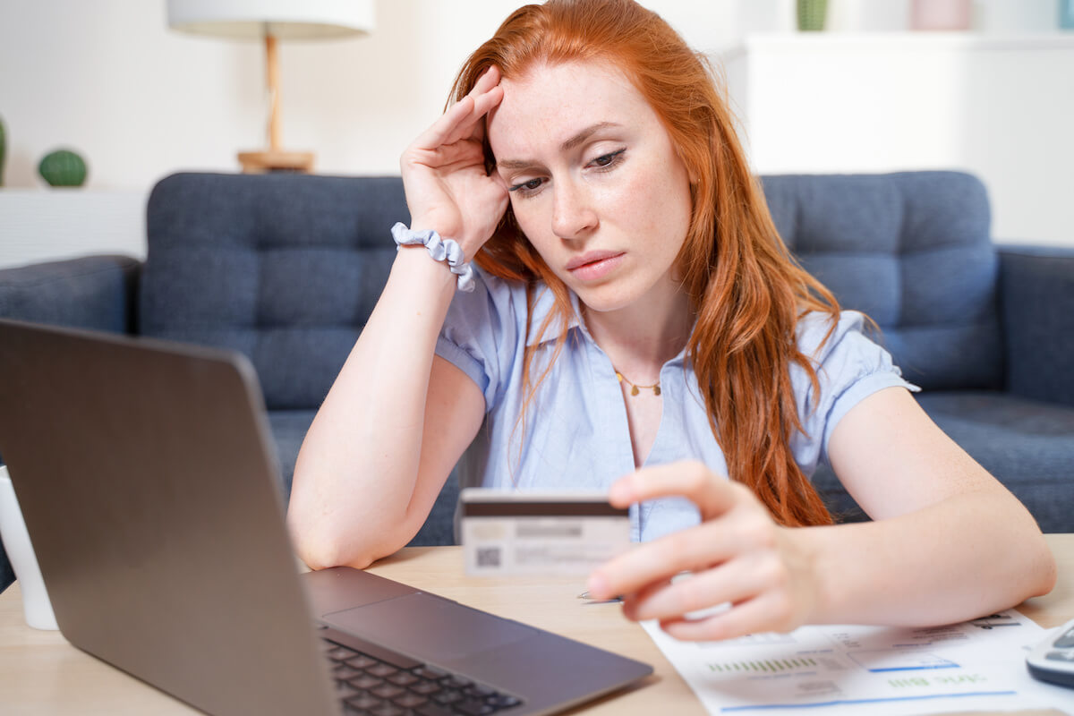 Worried woman looking at her credit card