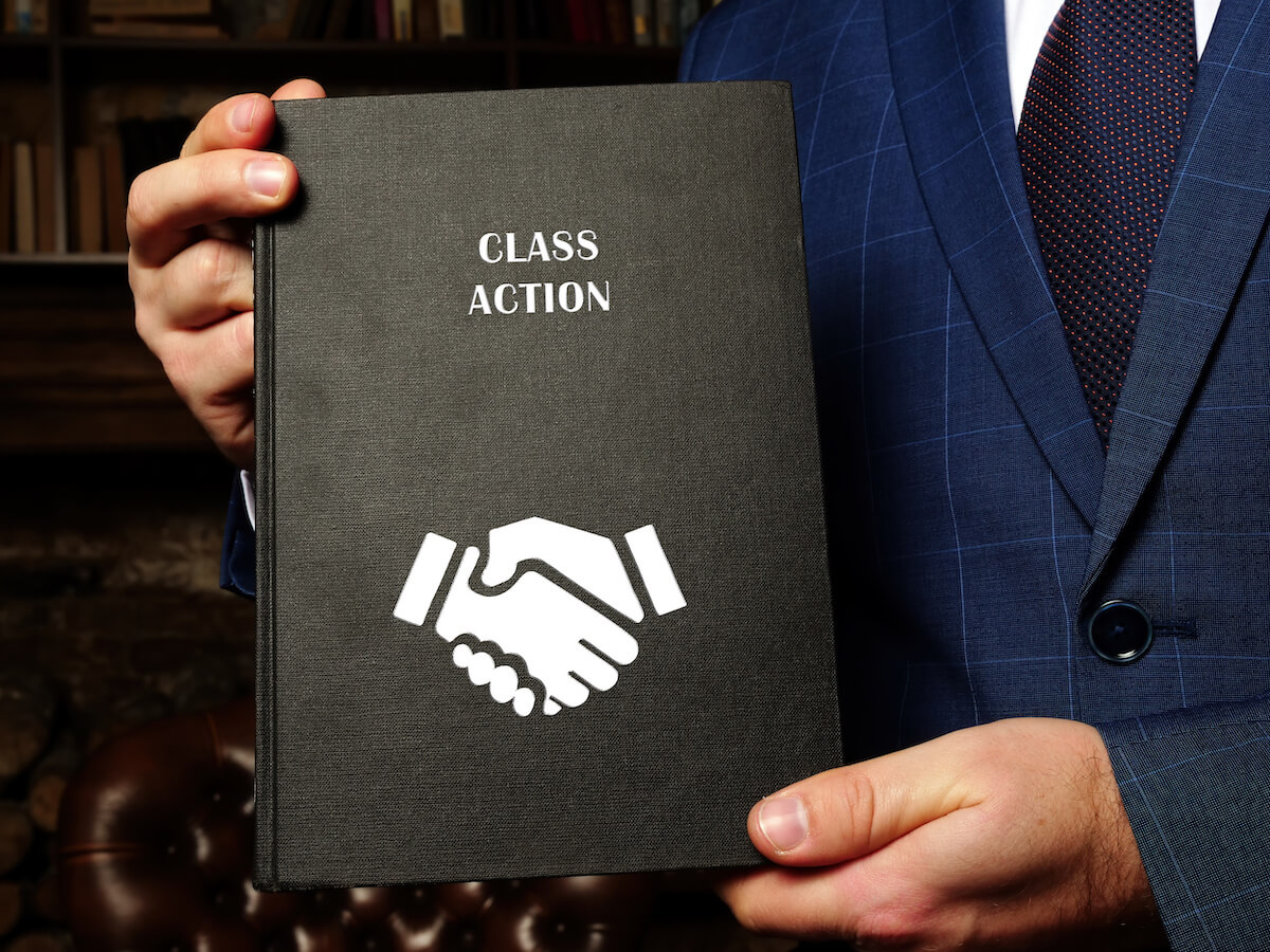 Class action lawsuit against timeshare companies: entrepreneur holding a CLASS ACTION book