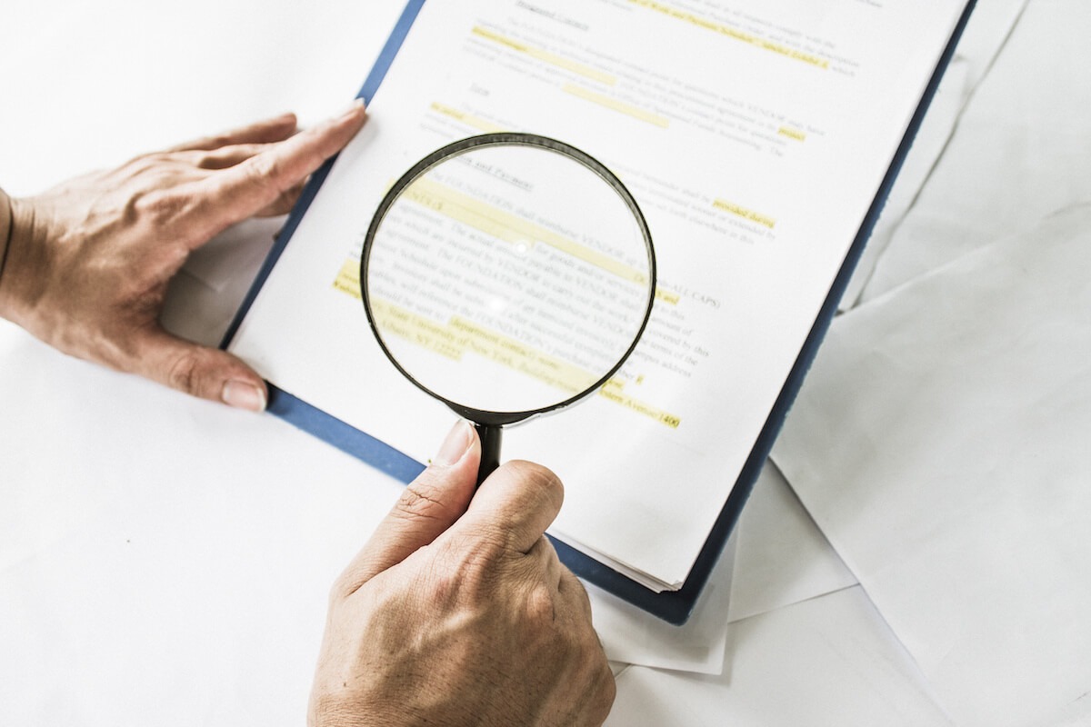 Cancel timeshare contract: person reading a document using a magnifying glass