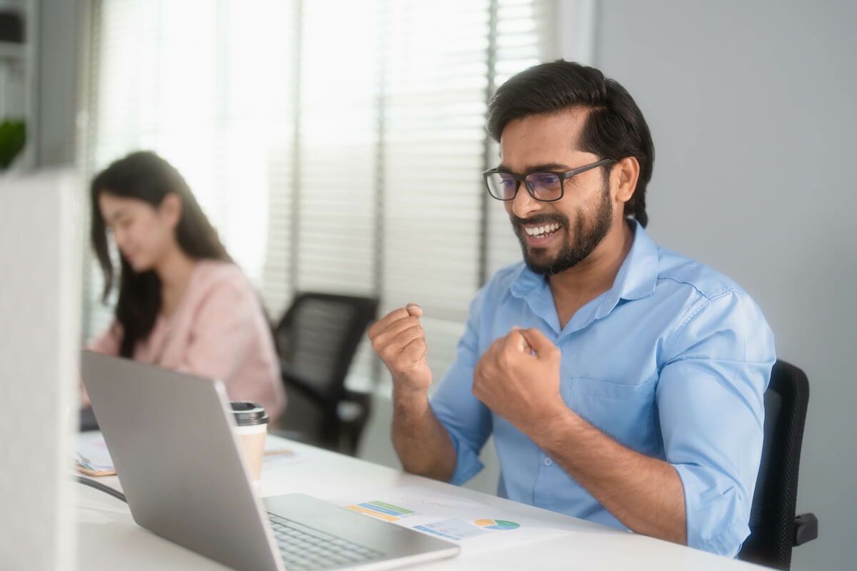 Employee happily looking at his laptop
