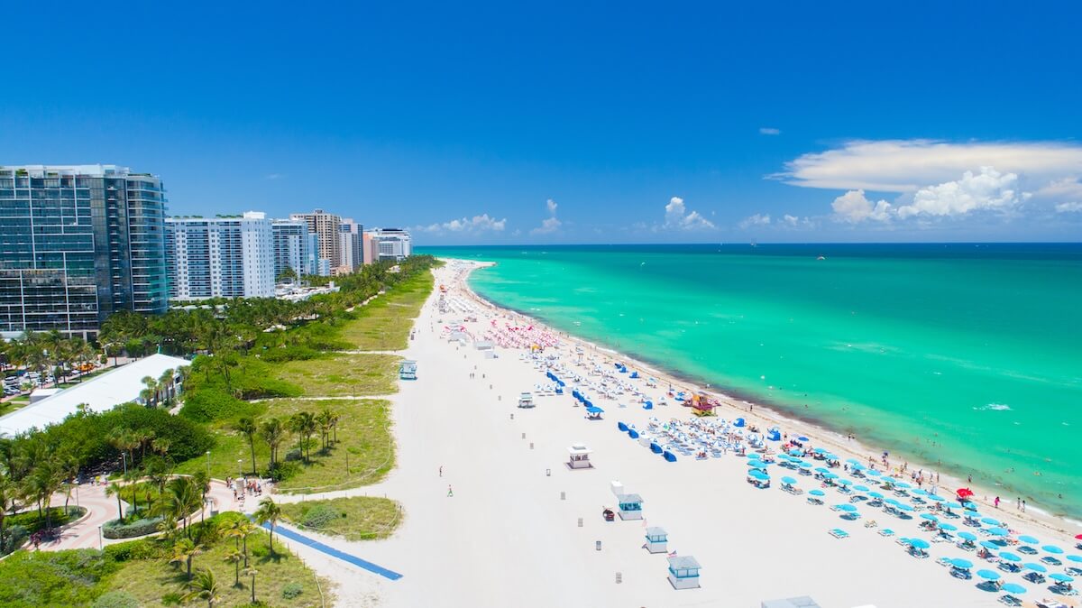 Bluegreen acquisition: A view of a Miami beach with the ocean on one side and condos on the other