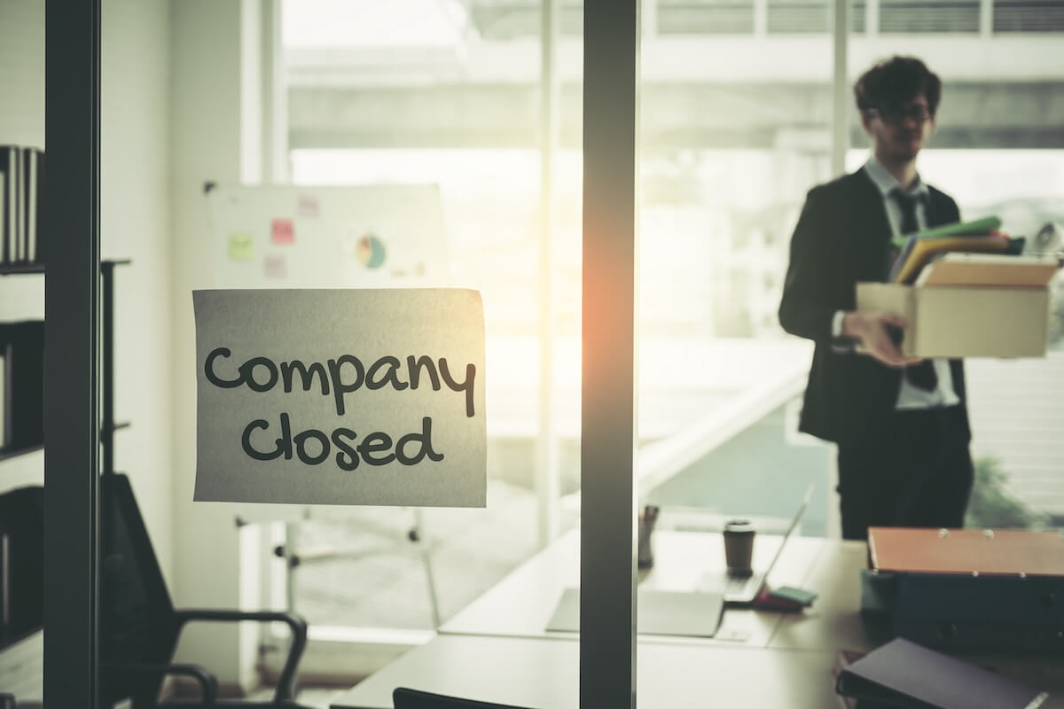 Company closed sign on a glass door