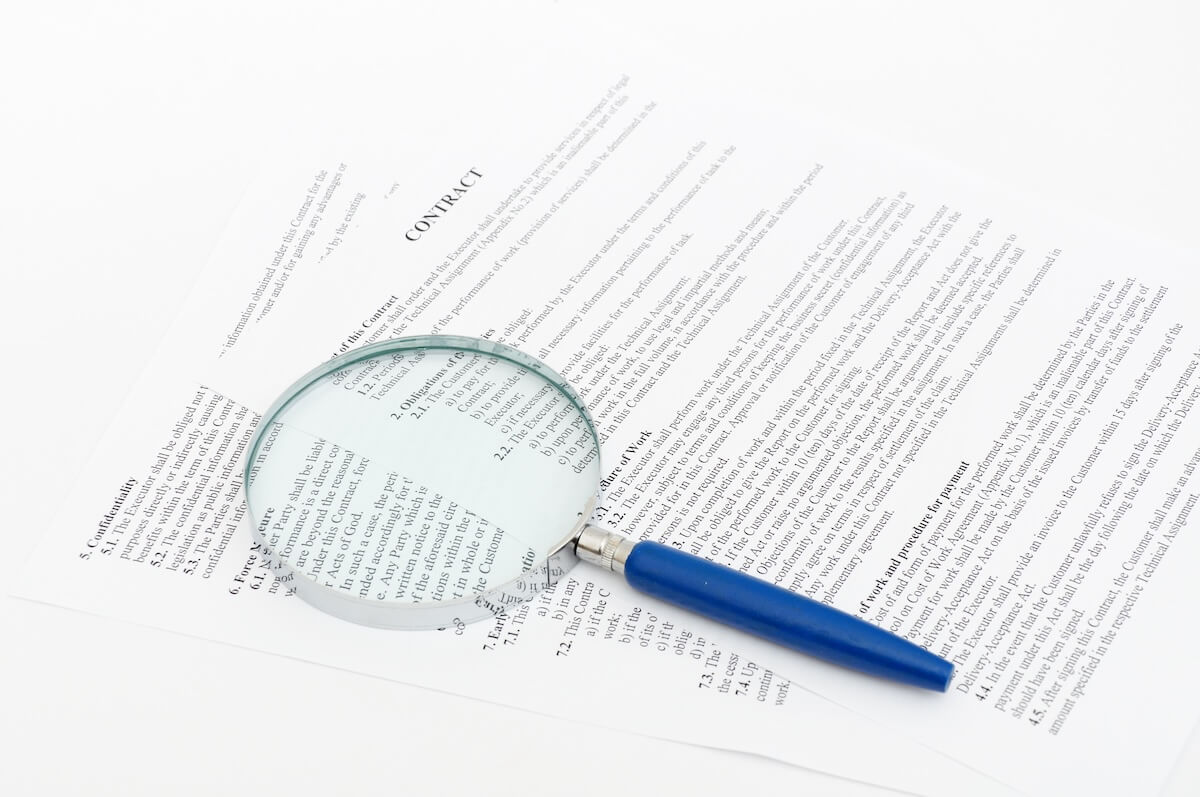 Contract and a magnifying glass on a table