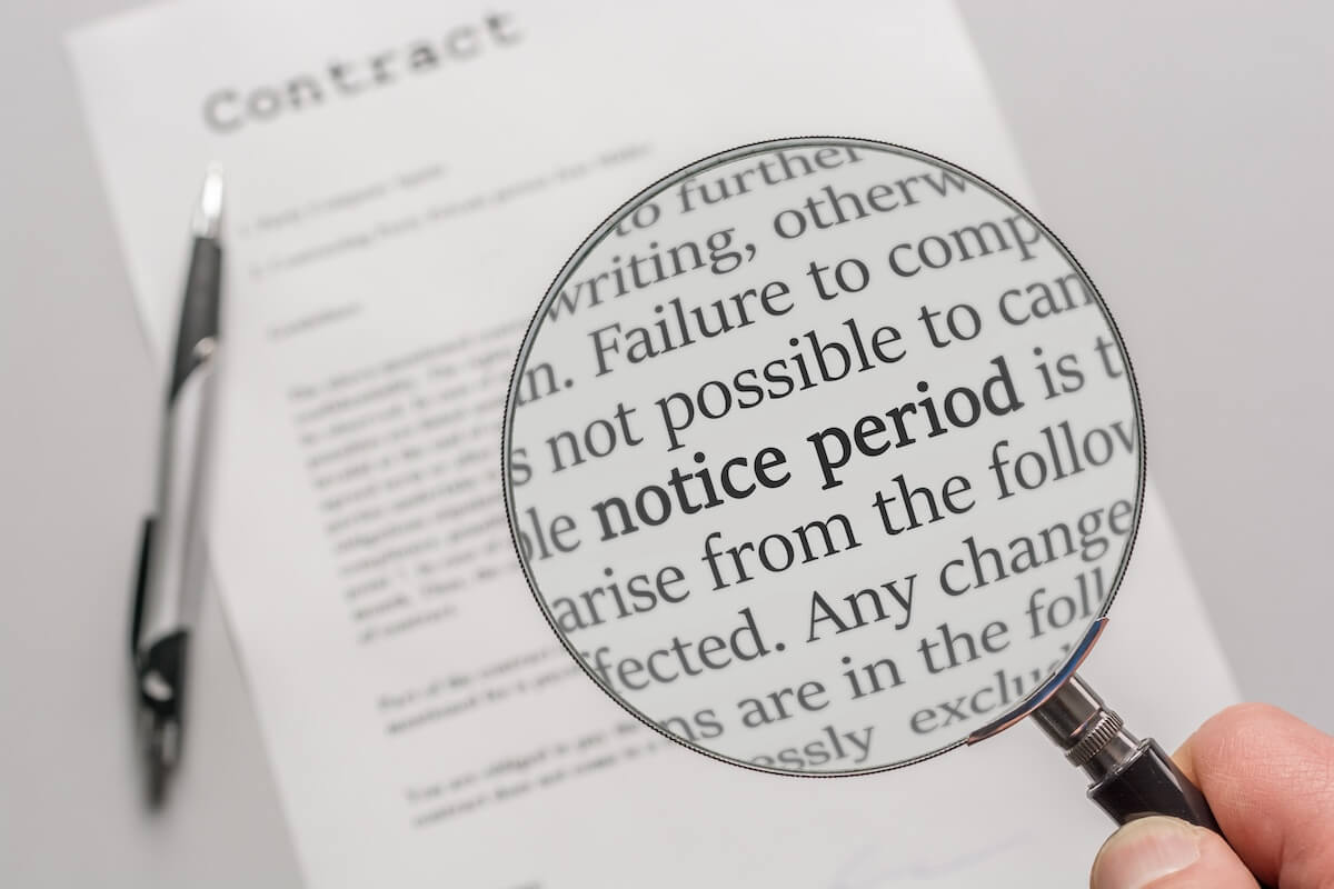 Person using a magnifying glass to read a contract