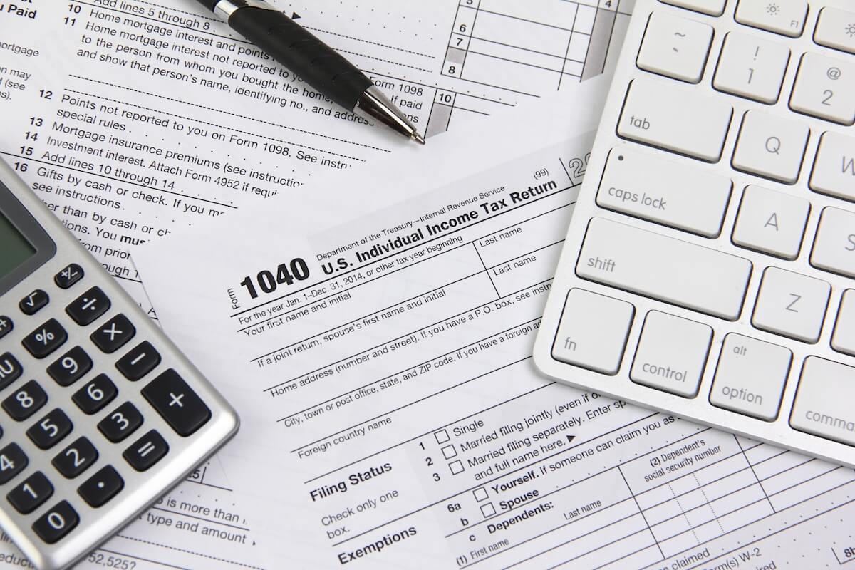 1040 tax form, a calculator, and a pen