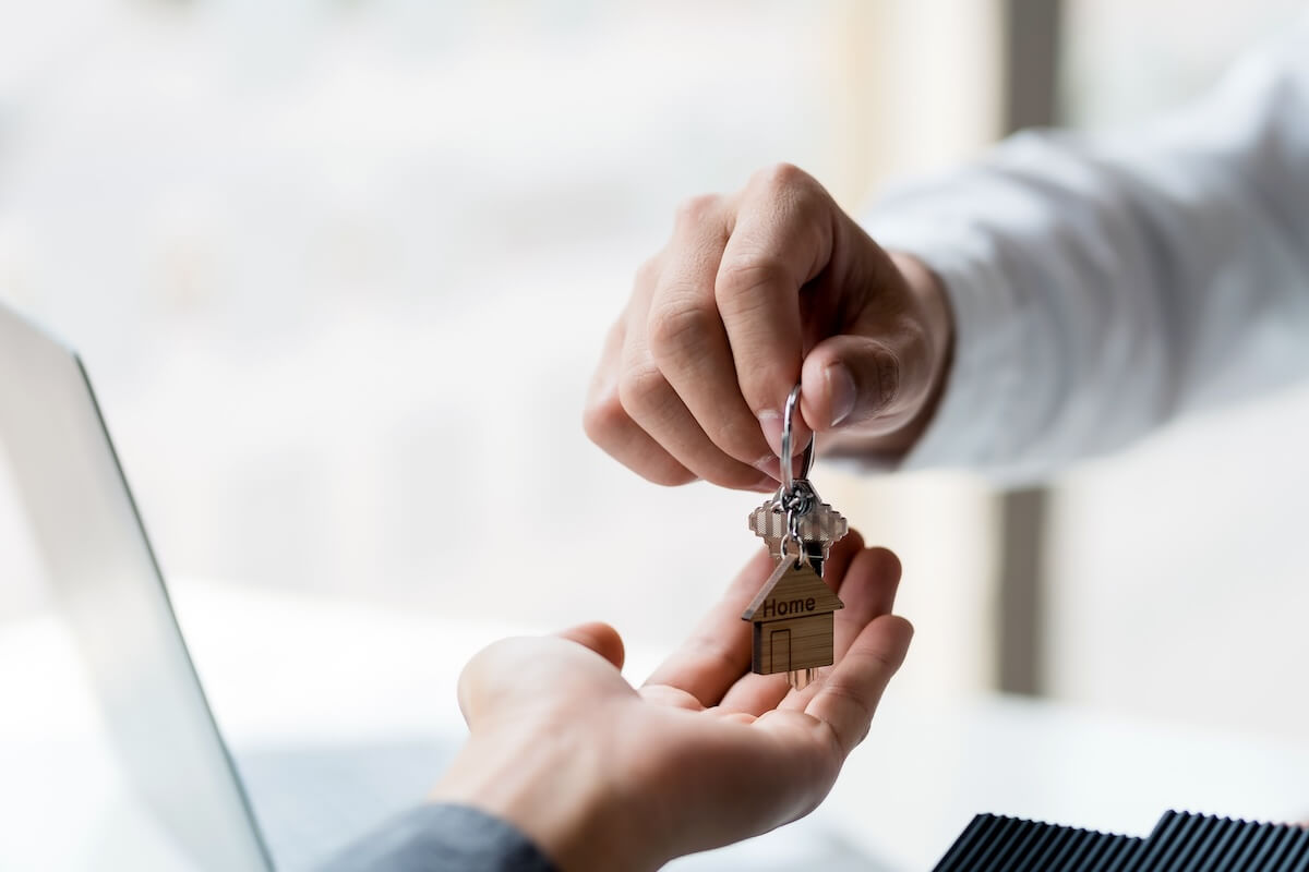 How to Transfer a Timeshare to Someone Else: person handing a house key to a client