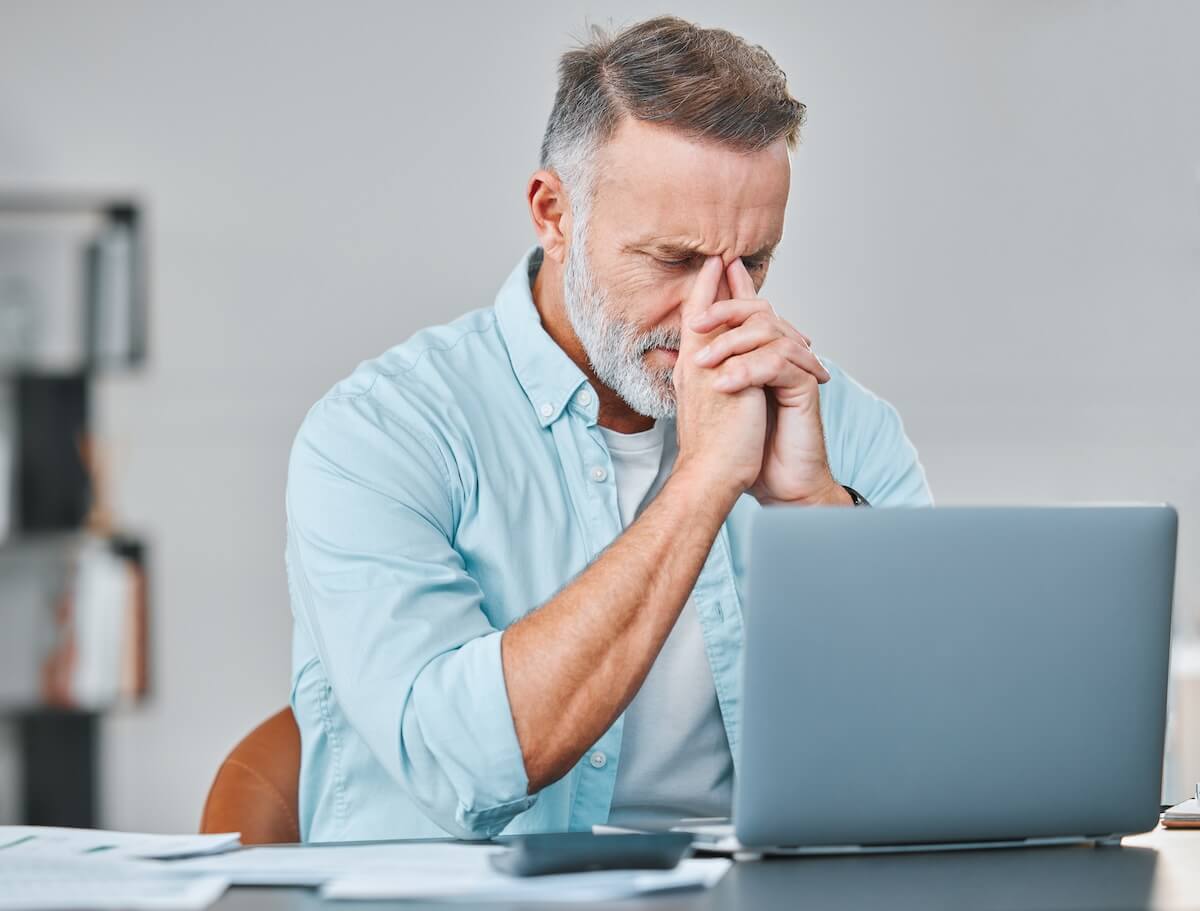 Stressed man looking at his laptop