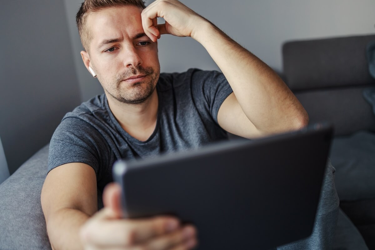 Stressed man using his tablet