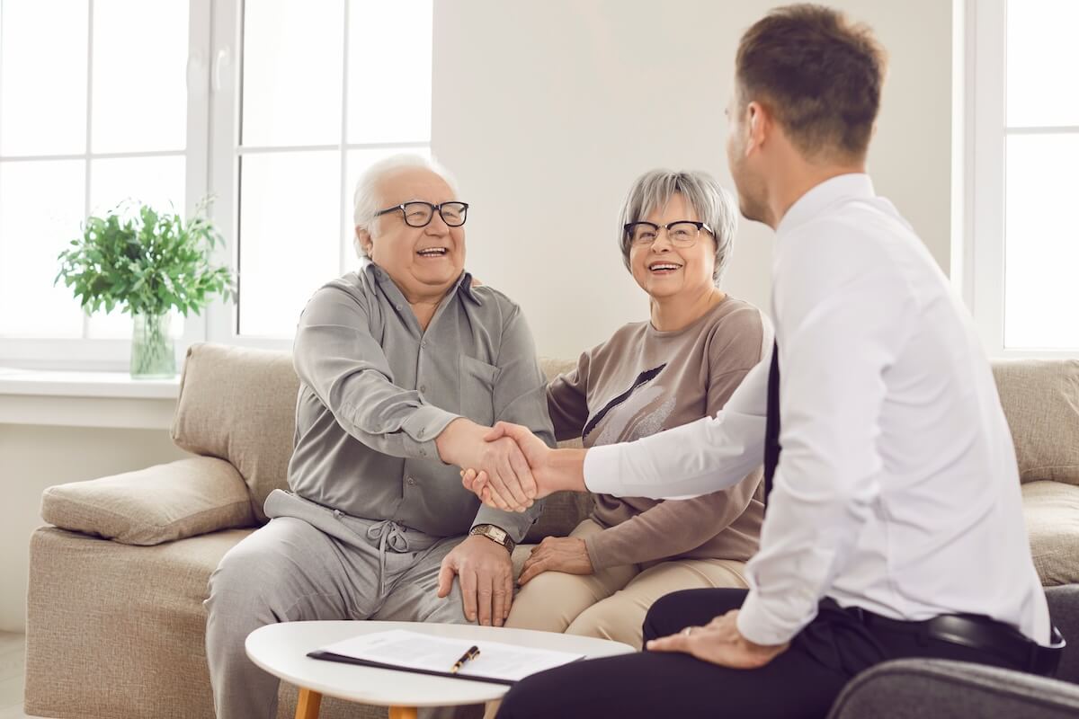 Senior couple shaking hands with an attorney