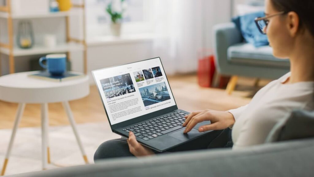 The Role of Reviews in Choosing a Timeshare Exit Company: woman sitting on a couch while using a laptop