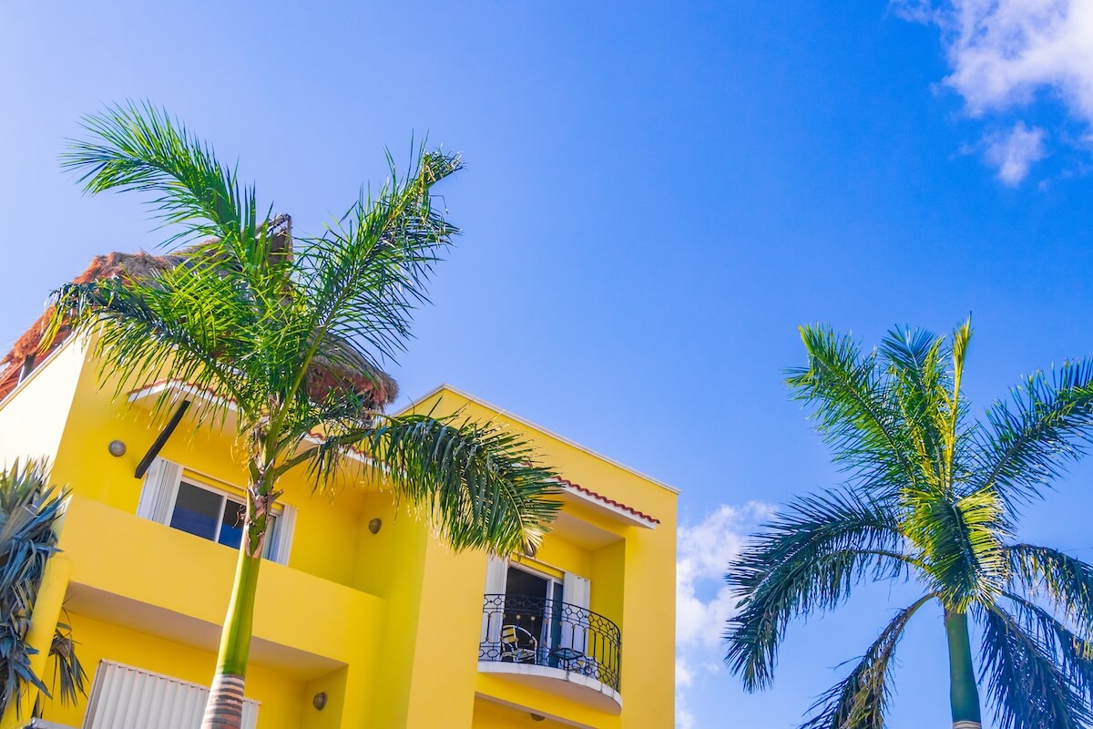 How to Legally Exit an International Timeshare Contract: yellow building and 2 coconut trees