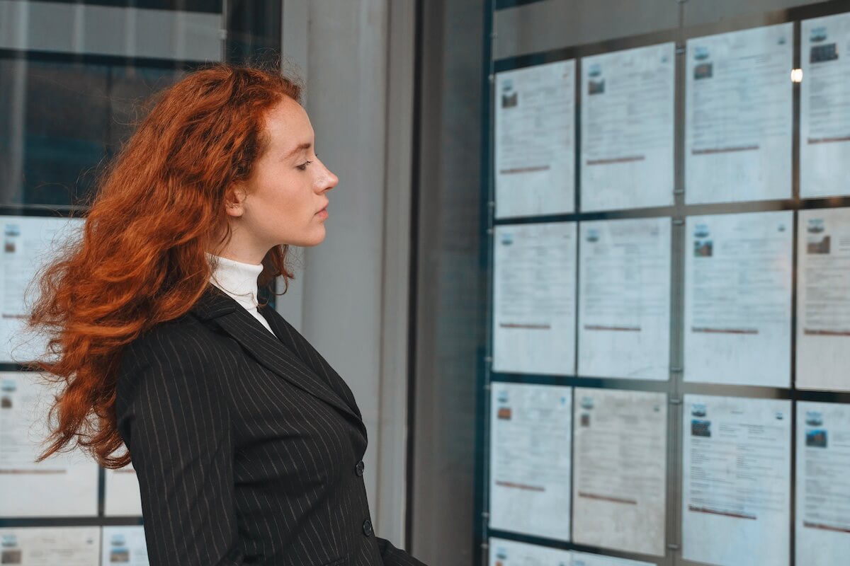 Woman looking at some documents posted on a glass wall