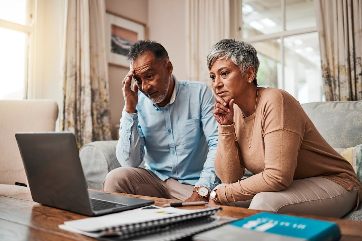 Exiting third-party timeshare: stressed senior couple watching something on a laptop