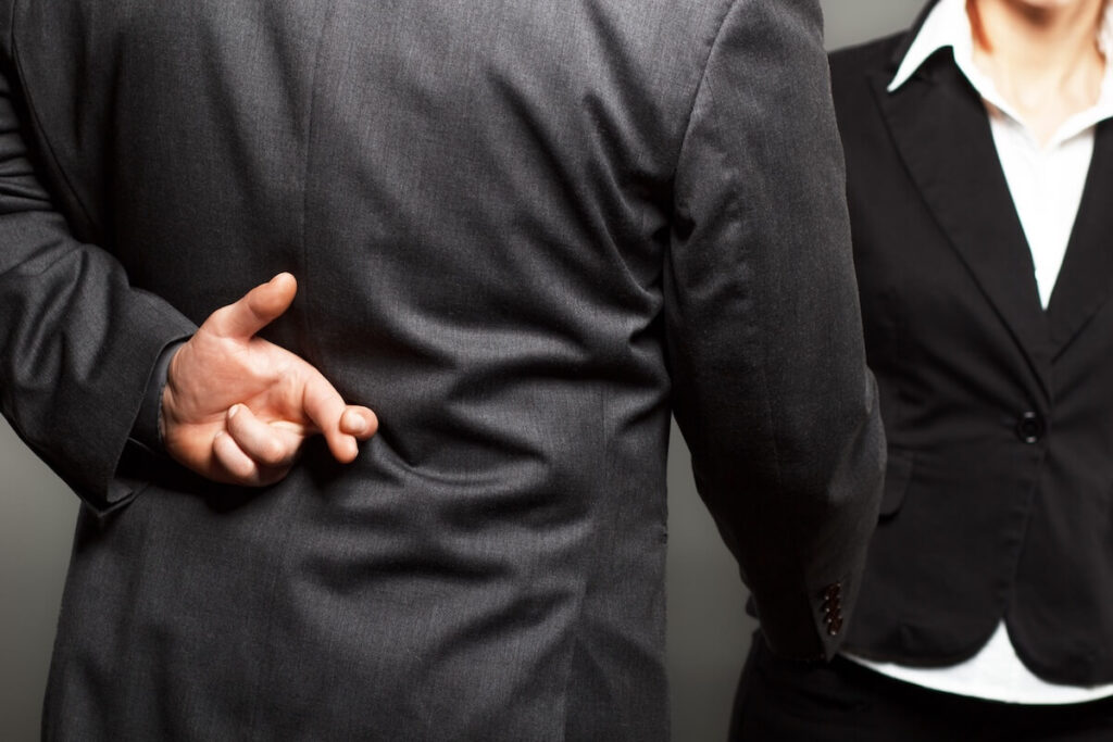 How Timeshare Companies Use High-Pressure Sales Tactics: entrepreneur crossing his fingers behind his back