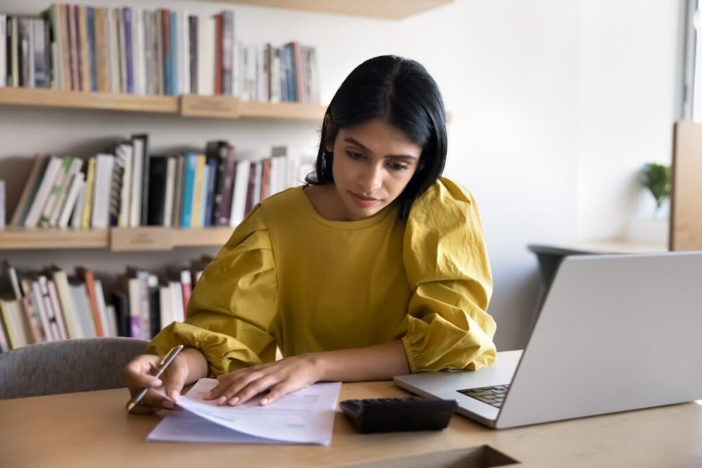 The Hidden Costs of Timeshare Ownership: entrepreneur looking at a calculator while holding a document