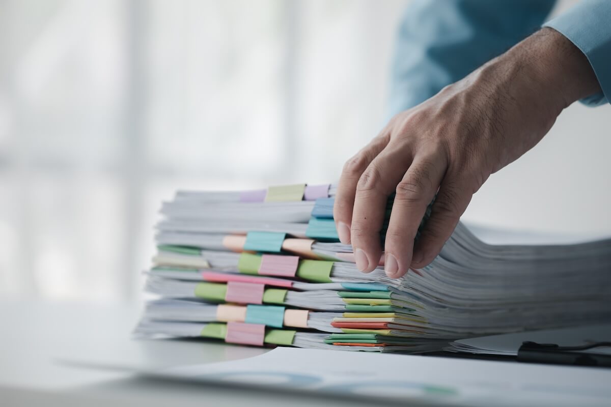 Hand holding a stack of documents