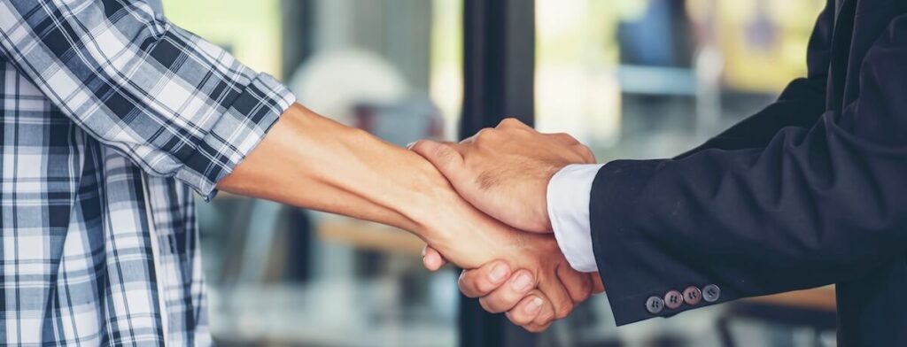 Timeshare exit company risks: real estate agent shaking hands with his client